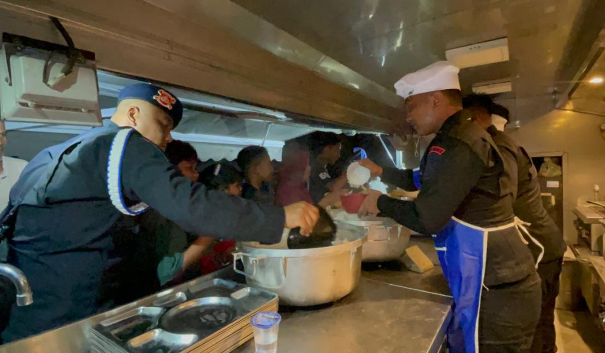 Personel Polda Aceh membagikan makanan siap saji di dapur umum kepada warga terdampak banjir, Sabtu (29/11/2025). Langkah ini bekerja sama dengan SPGG untuk memastikan pemenuhan gizi darurat bagi pengungsi. (Foto: Dok. Humas Polda Aceh).