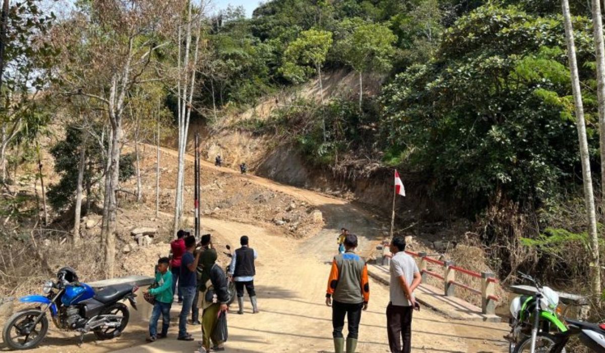 Warga berdiri di jalur alternatif pada akses jalan penghubung Kecamatan Silih Nara–Kecamatan Celala, Aceh Tengah, yang terhubung ke Kabupaten Nagan Raya melalui Jembatan Skep (Totor Skep), Jumat (26/12/2025). Jalur darurat ini dibuka setelah badan jalan lama terputus akibat bencana. (Foto: Dok. Pemkab Aceh Tengah).