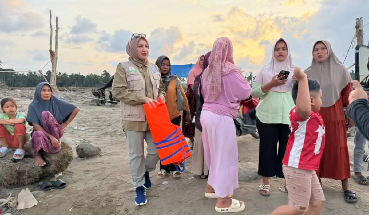 Ketua TP PKK Aceh Marlina Muzakir menyerahkan bantuan kepada warga terdampak banjir bandang di lokasi pengungsian warga Gampong Lhok Gunci, Kecamatan Sawang, Aceh Utara, Senin (22/12/2025). (Foto: Dok. TP PKK Aceh).
