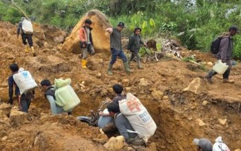 Warga memanggul logistik melintasi jalur lumpur di Desa Kem, Bener Meriah, Jumat (12/12/2025), setelah longsor memutus akses darat menuju Aceh Utara. (Foto: Dok. Posko Rakyat/KoranAceh.Net).